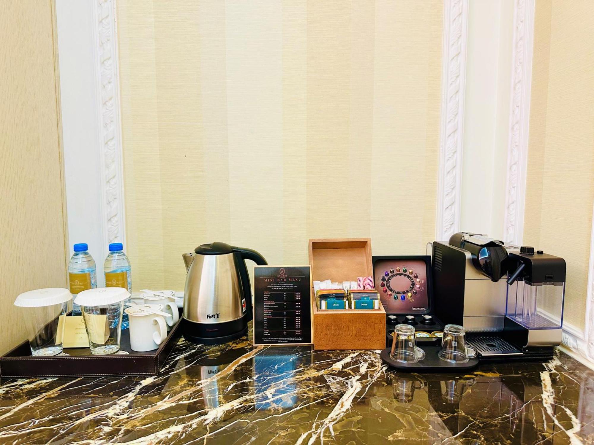 Royal Rose Abu Dhabi, A Curio Collection By Hilton Affiliated Hotel Exterior foto The photo shows a hotel or room beverage station on a marble countertop. It includes:

- Two bottles of water.
- A kettle for boiling water.
- Two cups and a small container, likely for sugar or cream.
- A menu or information card detailing drink opt